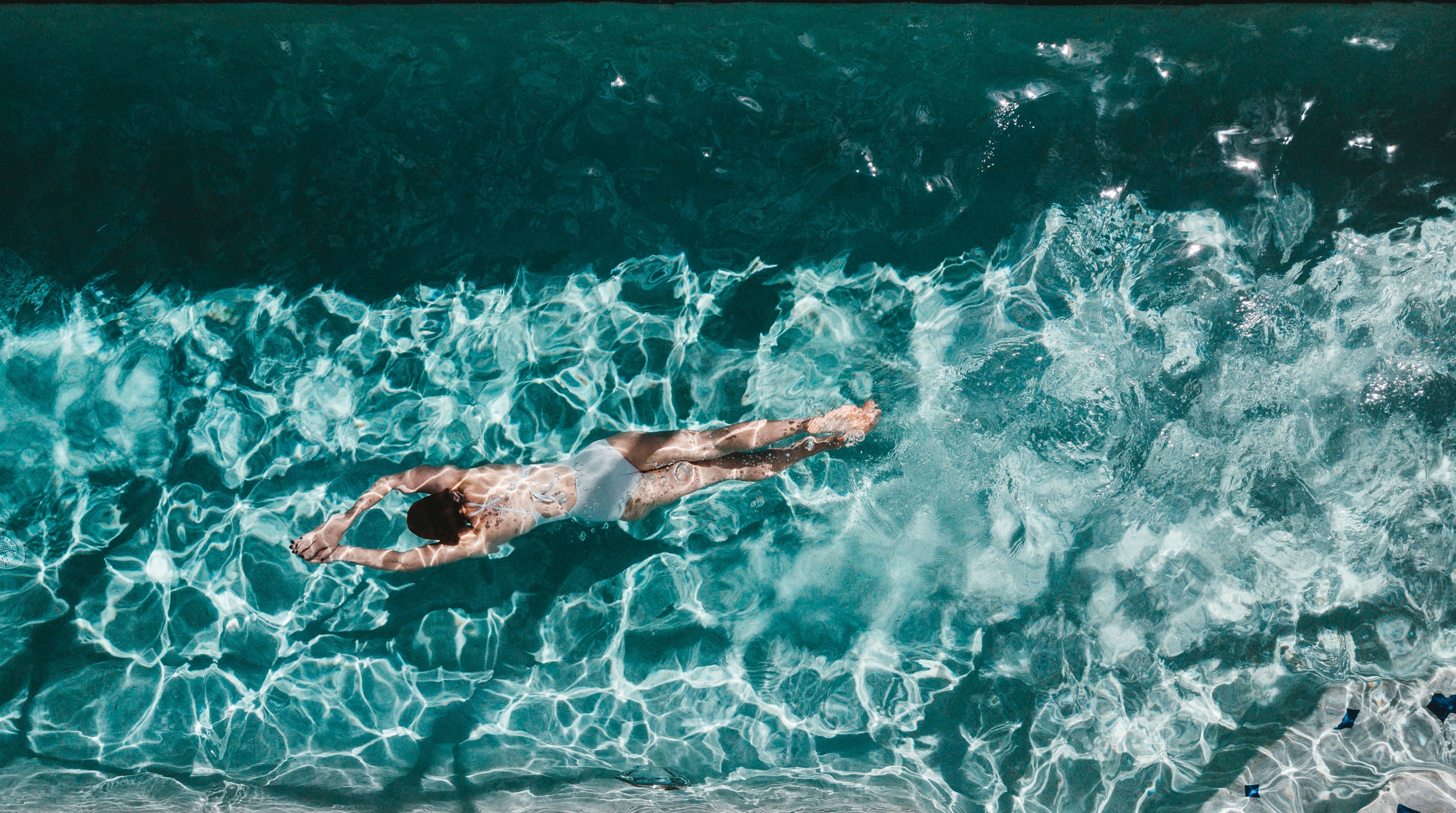 top-view-of-a-woman-gliding-through-a-pool-underwater.jpg